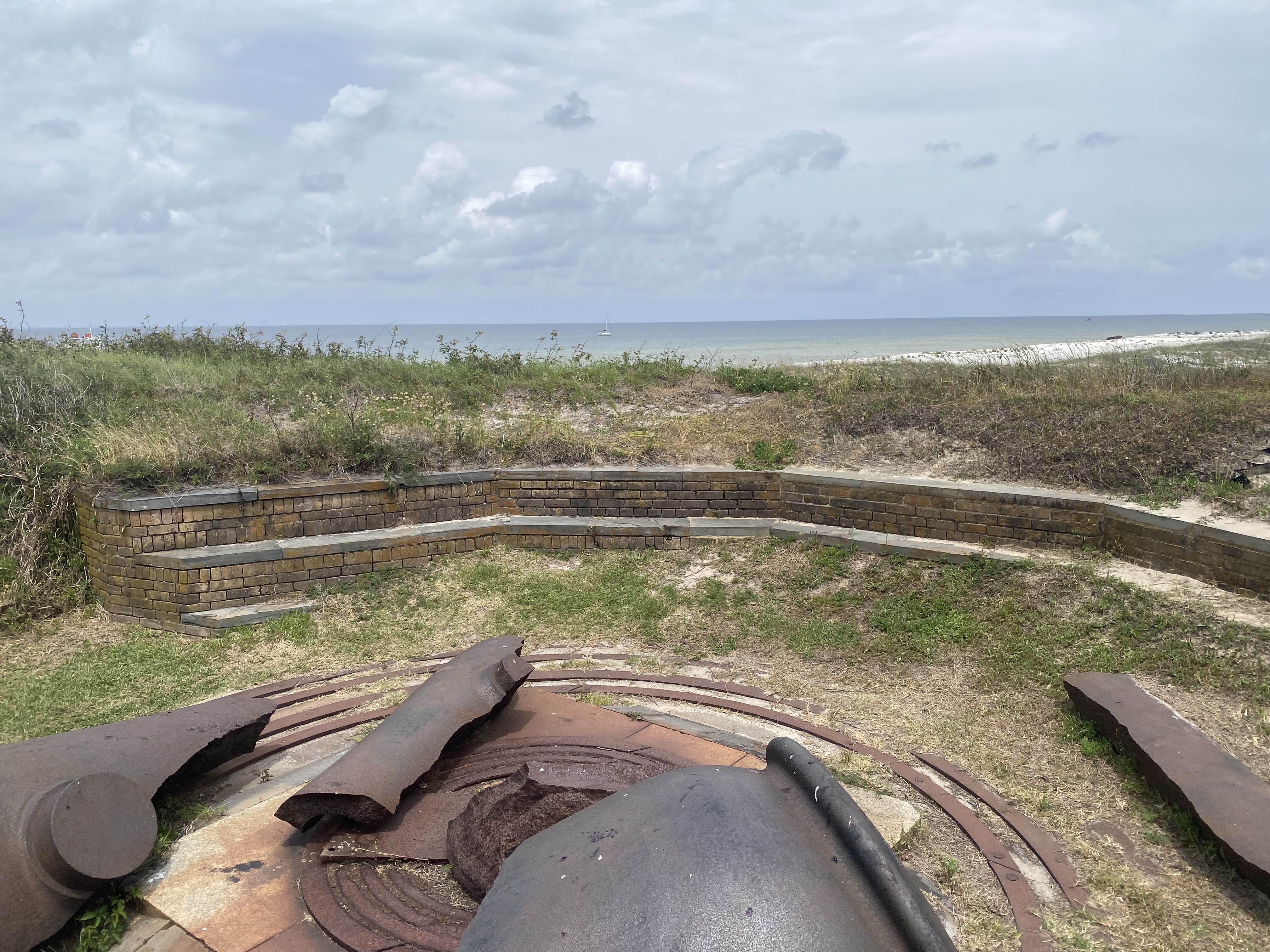 Canon remnants with sailboat in distance